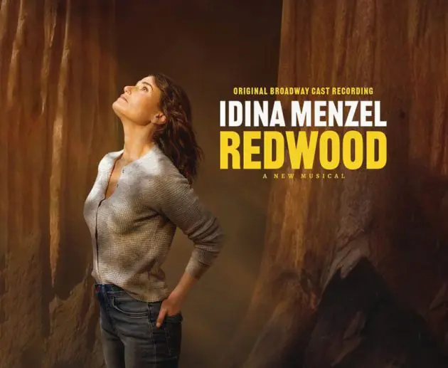 Promotional image for the original Broadway cast recording of Redwood, a new musical starring Idina Menzel. Idina stands among towering redwood trees, gazing upward with a serene expression, wearing a casual gray shirt and jeans. The title text "IDINA MENZEL REDWOOD" appears boldly in white and yellow on the right side.
