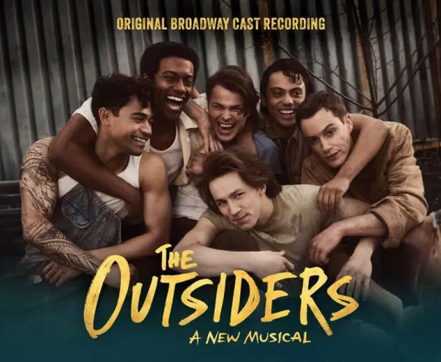 The cast of The Outsiders: A New Musical smiles and embraces each other in front of a corrugated metal backdrop. The text "Original Broadway Cast Recording" appears above them, and the show's title "The Outsiders: A New Musical" is displayed at the bottom.